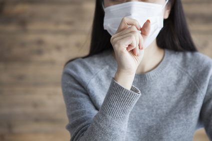 Woman wearing a mask has a cough