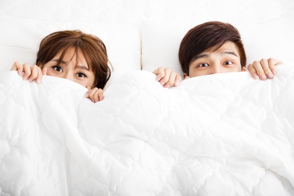 surprised young couple lying in bed