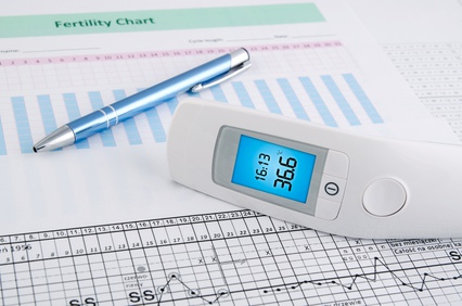 Contactless thermometer on fertility chart background